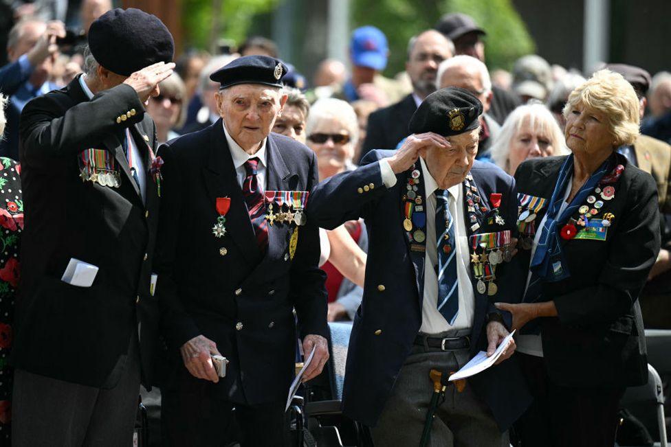 104-year-old Normandy veteran John Gillespie (centre left) and Normandy veteran Simeon Mayou (centre right) attend an annual service to remember the Normandy Landings at the National Memorial Arboretum in Stafford, central England on June 6, 2024. 