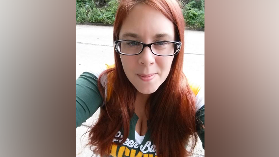 Aimee Betro, in a selfie taken from social media, with long straight hair and wide glasses. She is squinting slightly at the camera.