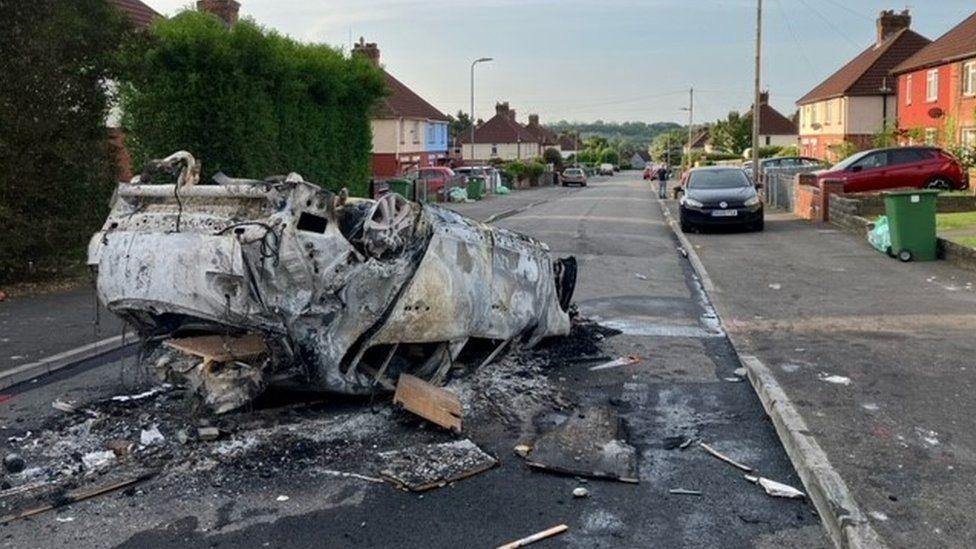 Car wedi llosgi ar ôl y terfysg yn Nhrelái ym mis Mai 2023