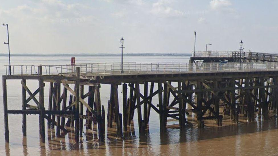 Victoria Pier on the banks of the Humber Estuary it is a wooden construction with legs embedded in the water holding up a wooden platform with metal fencing all around it
