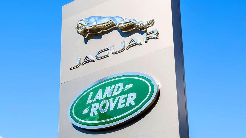 The Janguar Land Rover sign seen outdoors, with the blue sky behind it 