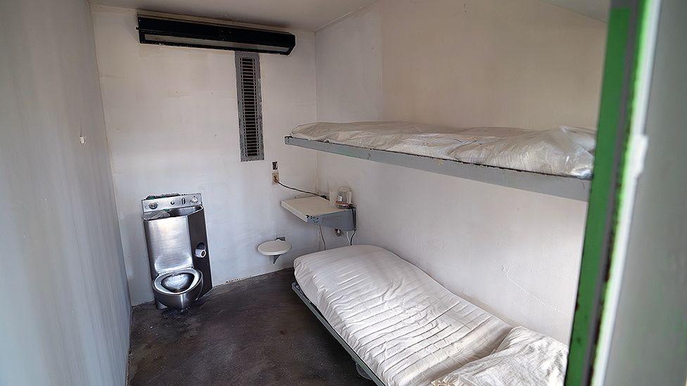 An austere prison cell at Estelle Supermax Penitentiary with a toilet, sink and bunk beds 