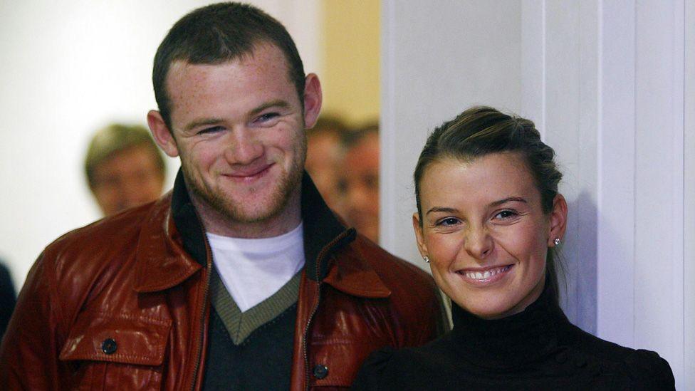 Wayne and Coleen Rooney standing next to each other and both smiling on a visit to Alder Hey Children's Hospital in 2006