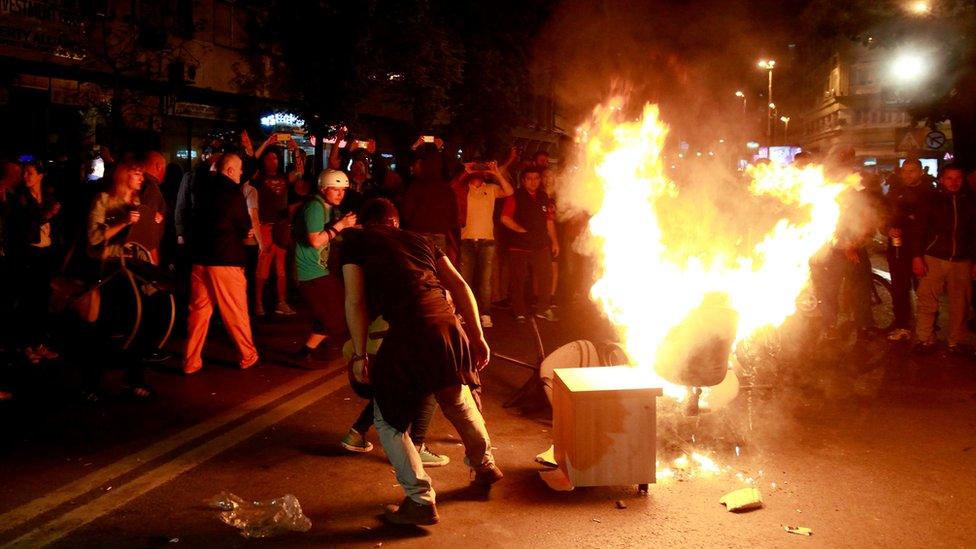 Protestors burn furniture taken out of the demolished President’s office in downtown Skopje, Macedonia, late Wednesday, April 13, 2016.