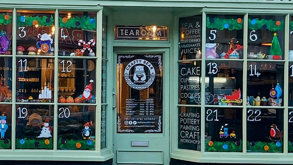 An advent calendar painted on a shop's windows by Bianca Garcia