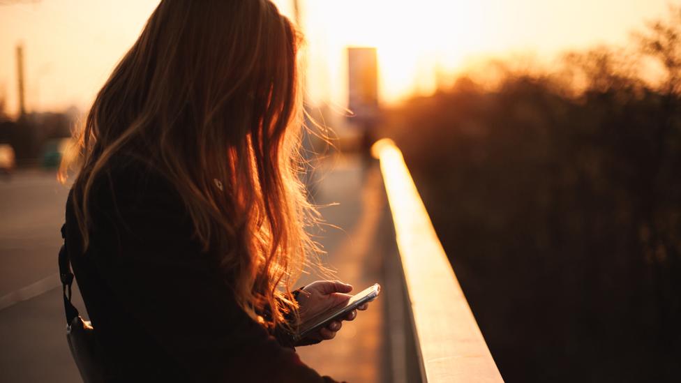 Picture of a young woman looking at her mobile phone