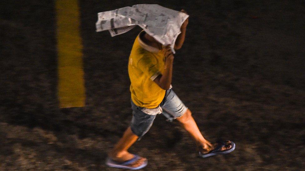 An Indian man covers his face amid a dust storm in Delhi on 13 May 2018.