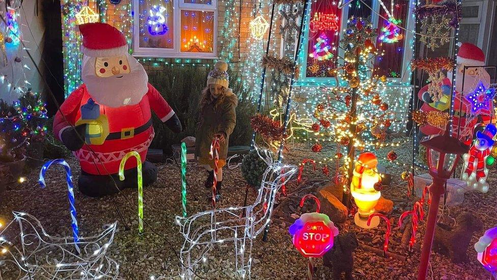 Girl stood in the middle of Christmas lights at Axe Close