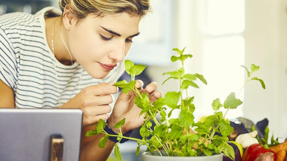 Young woman smelling mint