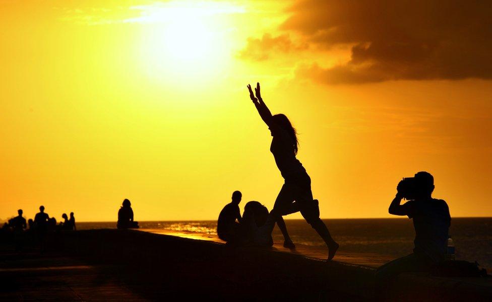 People gather to enjoy the sunset on the Malecon