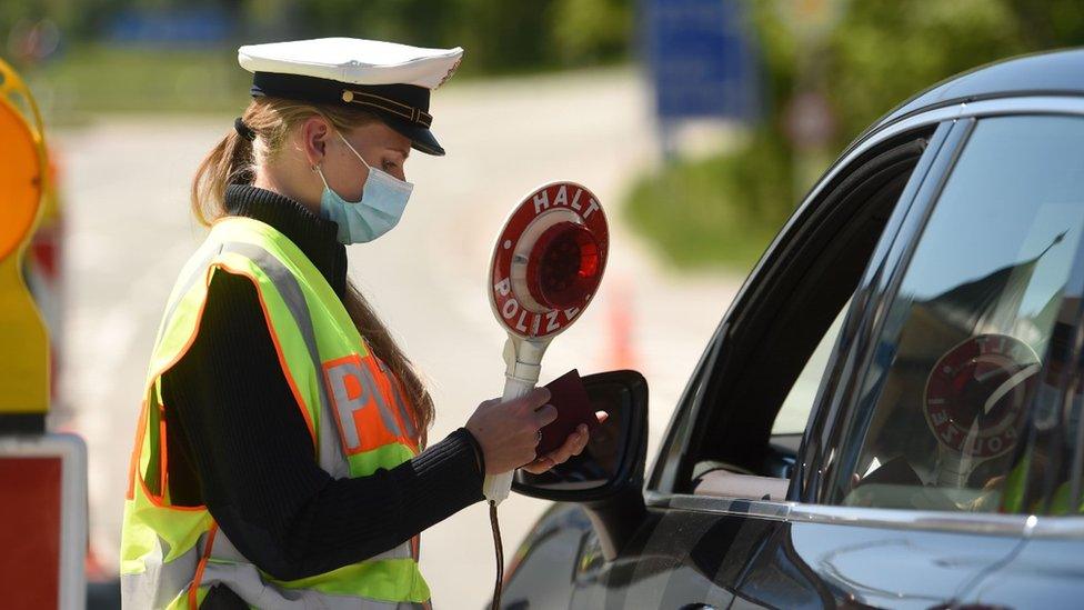 A German police officer wearing a protective mask during a car control at the border crossing between Austria and Germany, near the German village of Oberaudorf