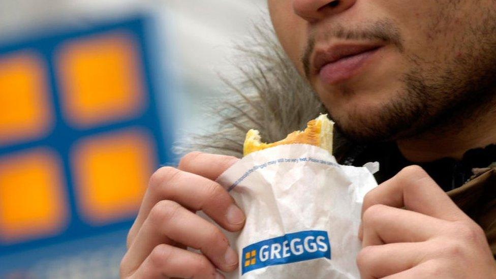 Man eating a Greggs sausage roll