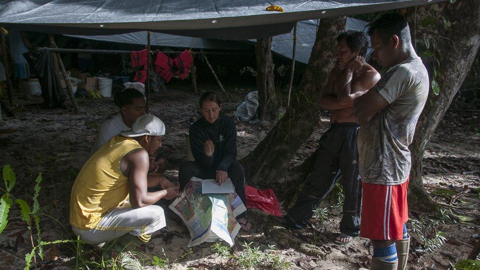 The Biodiversity Assessment Survey team discuss potential sites for camera traps while in the field