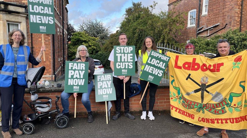 Six people on picket line with one large "Labour" banner and small "fair pay" placards