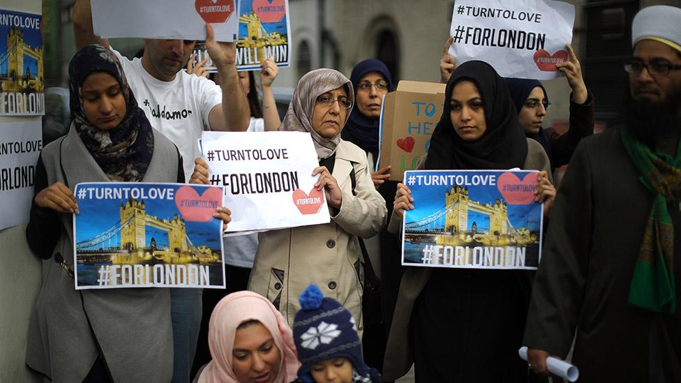 Muslim women hold up "turn to love" signs