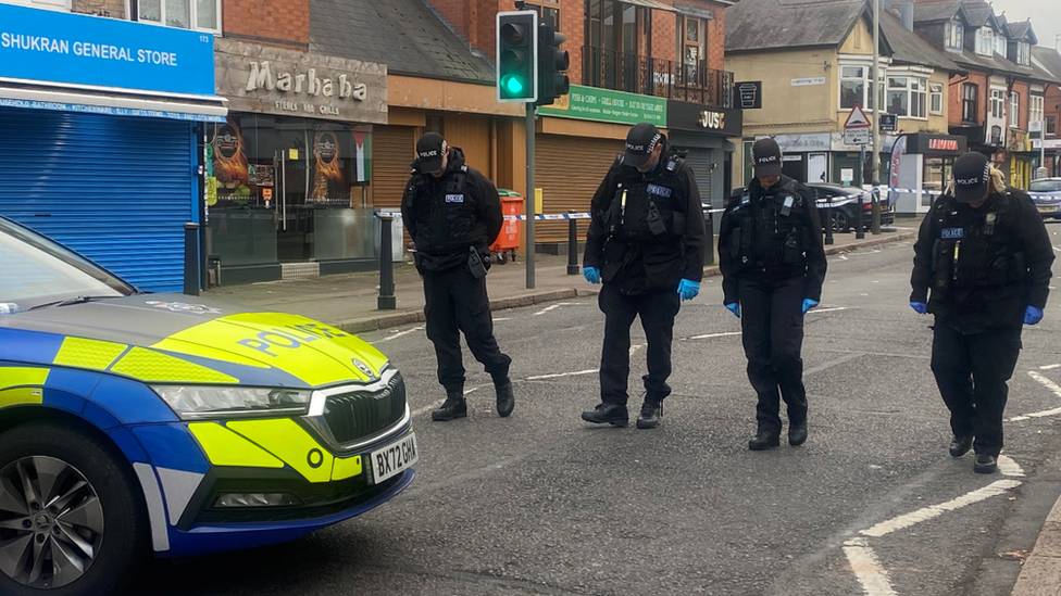 Police officers searching the road