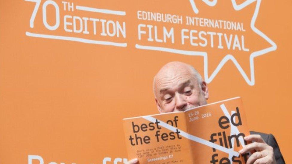 Man looking at Edinburgh International Film Festival brochure