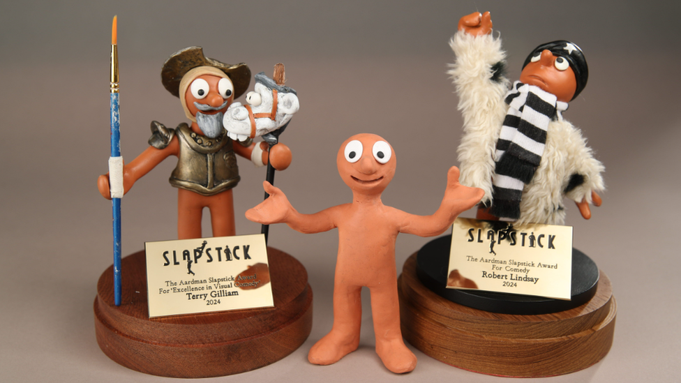 Two personalised Morph plasticine characters standing either side of the original Morph character