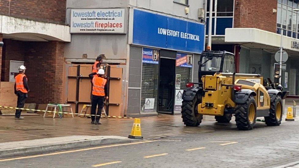 Banksy being removed from the side of an empty shop in Lowestoft