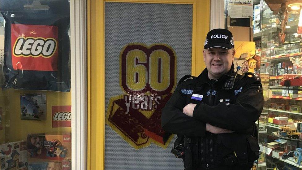 Sgt Tony Payne from Northamptonshire Police in front of Lego-covered toy shop.