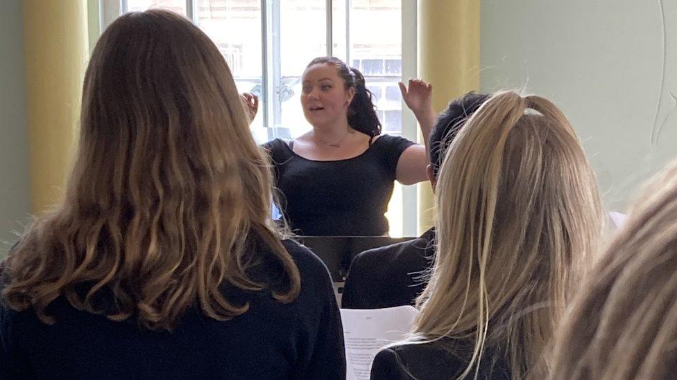 Caitlin conducting a group of musicians