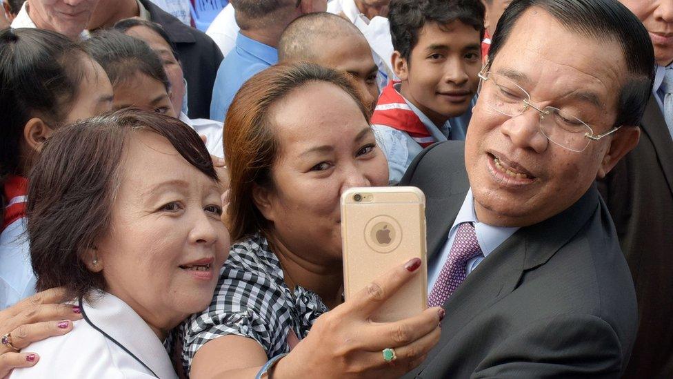 Hun Sen poses for a selfie with supporters during