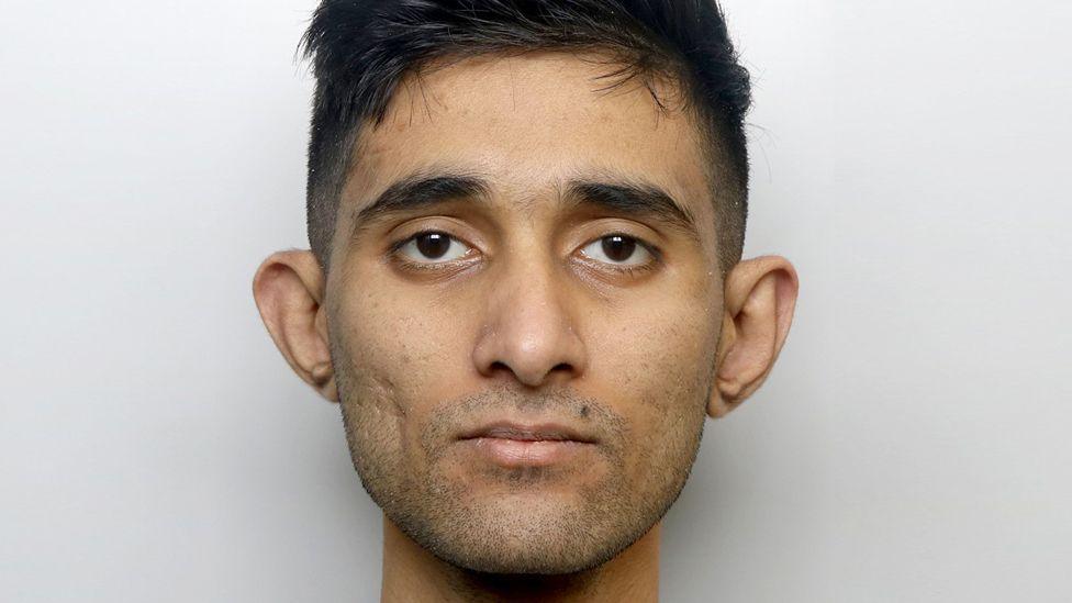 A man with short dark hair staring at the camera.