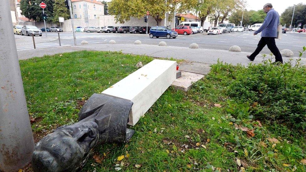 A man walks by a toppled down monument of Croatia's World War Two partisan, Rade Koncar, on 7 November 2018 in Split, Croatia