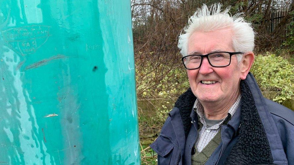 Dougie Reid standing beside the Corby Candle, 2019