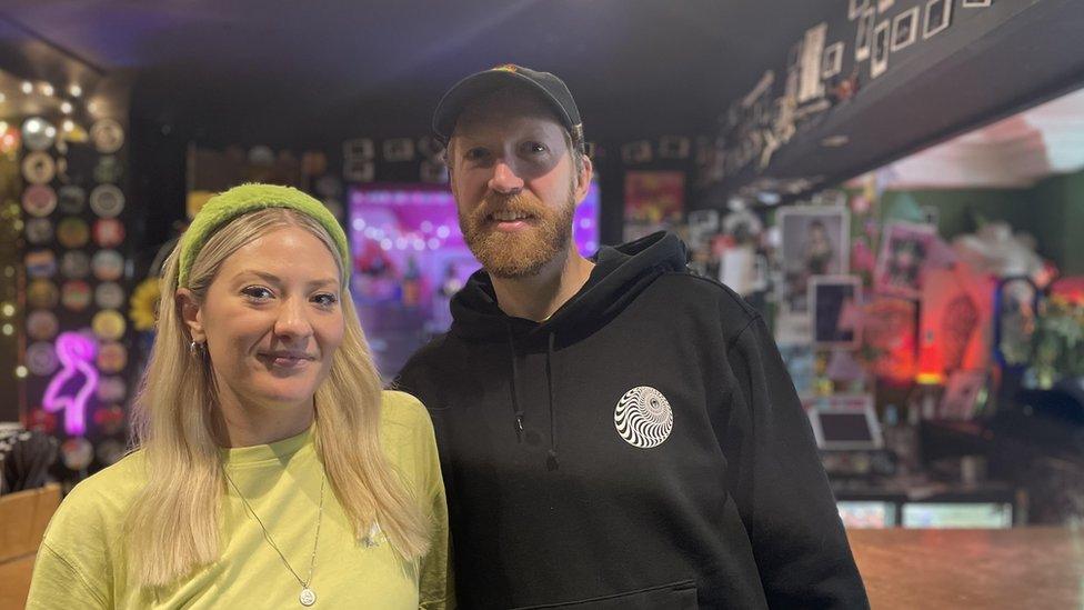 Married couple in front of bar