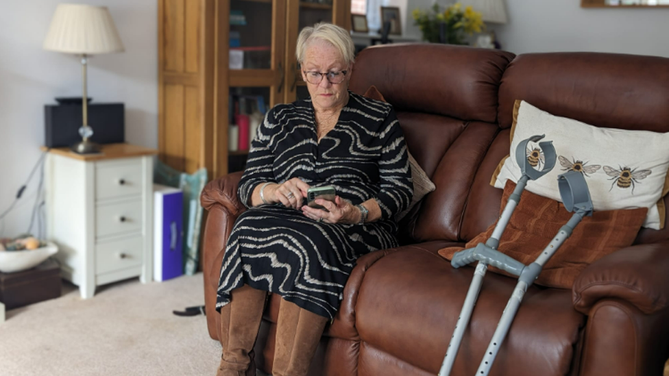 Janet Lowe using her phone to access the online forms for blue badge applications