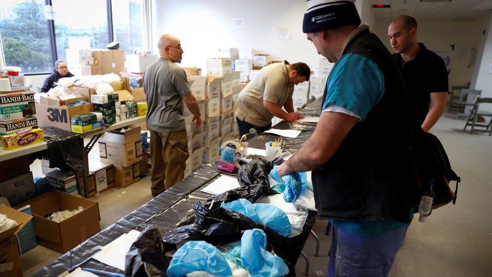 Nurses pick up personal protective equipment (PPE) and other supplies at a New York State emergency operations incident command centre