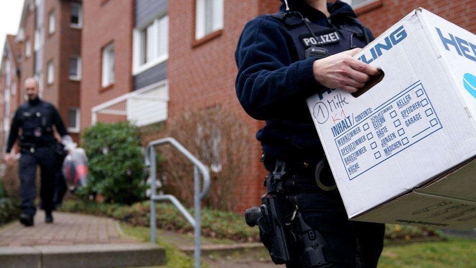 Police officers carry evidence from a property following a raid in connection with the militant neo-Nazi group "Combat 18" near Berlin in Wildau, Germany, 23 January 2020