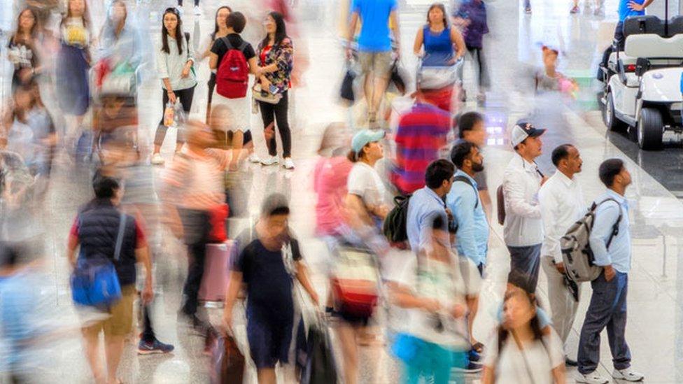 A blur of people move through a busy terminal at Hong Kong Chek Lap Kok International Airport