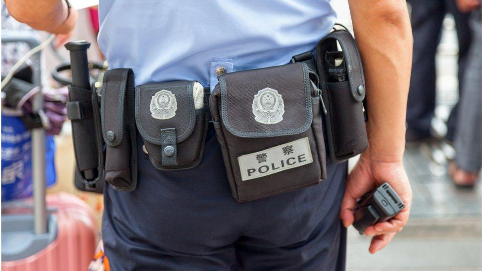 The lower half of a Beijing policeman's body, with his back to the camera