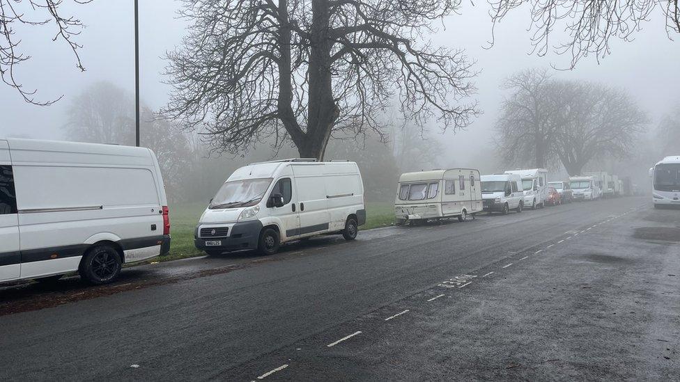 Vans lined up on a road running alongside The Downs in north Bristol