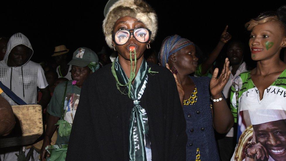 Supporters of president Yahya Jammeh gather and dance in a street of Bakau on April 4, 2017.