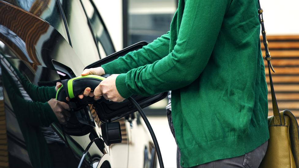 Woman charging electric car