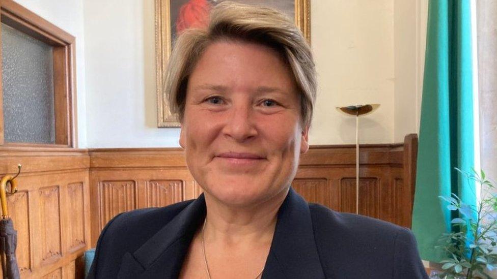 Sarah Dyke smiling, in a wood panelled room