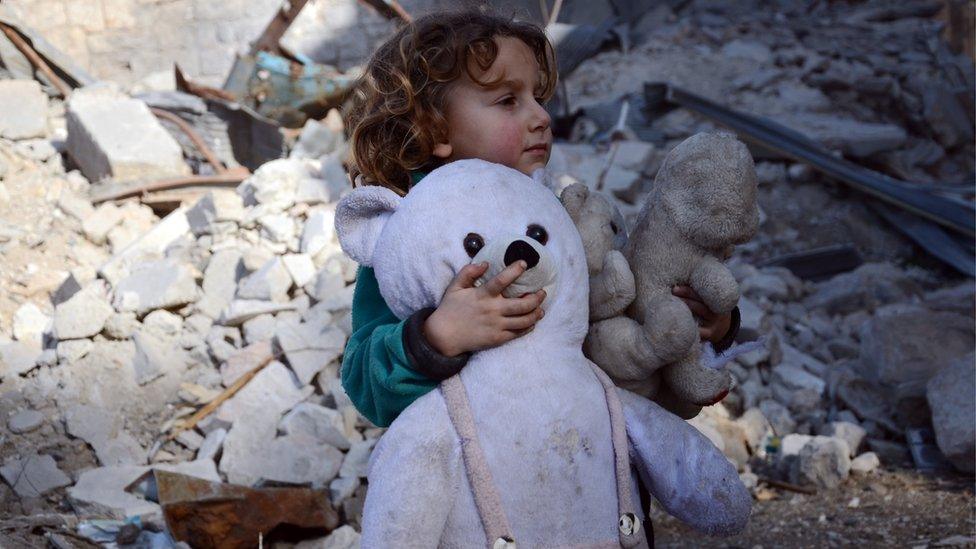 Syrian girl, holding her stuffed toy, stands next to the rubble of buildings in the northwestern Syrian border town of al-Bab on February 25, 2017 after Turkish-backed rebels announced the recapture of the town from the Islamic State (IS) group earlier in the week.