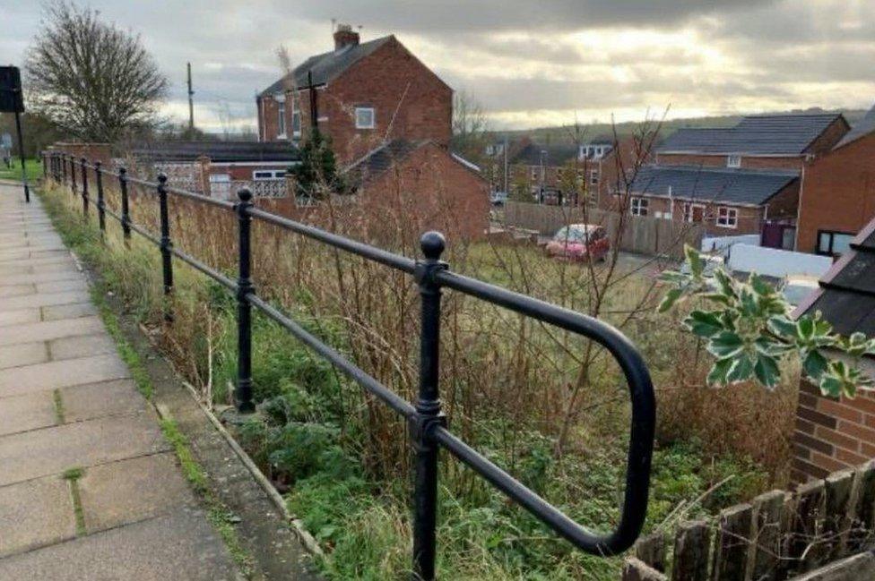 The planned site, an area of green space between houses