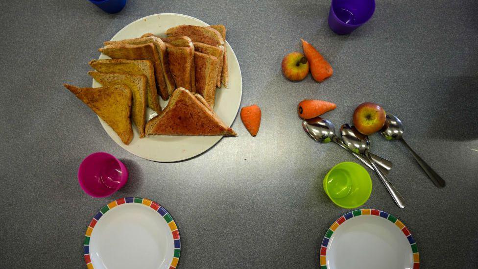 Overhead shot showing toast on a plate and bowls and crockery on table