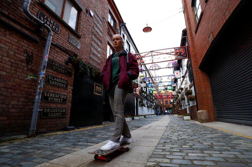 A young woman on a skateboard on a Belfast street