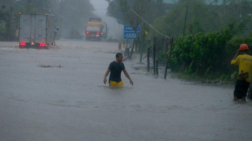 A man wades through a flooded highway at the height of Super Typhoon Haima, 20 October 2016.