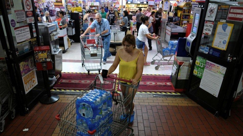 Shoppers buy food and water from a supermarket as Tropical Storm Dorian approaches in Cabo Rojo, Puerto Rico