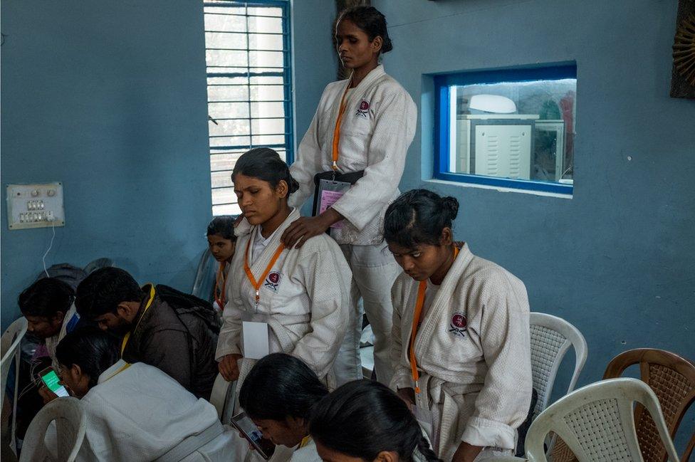 A woman rests on another women's shoulders.