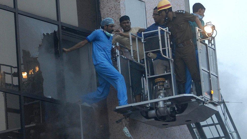 Rescue workers evacuate a hospital staff member as a fire engulfs the Advance Medicare and Research Institute (AMRI) hospital in the eastern Indian city of Kolkata on December 9, 2011