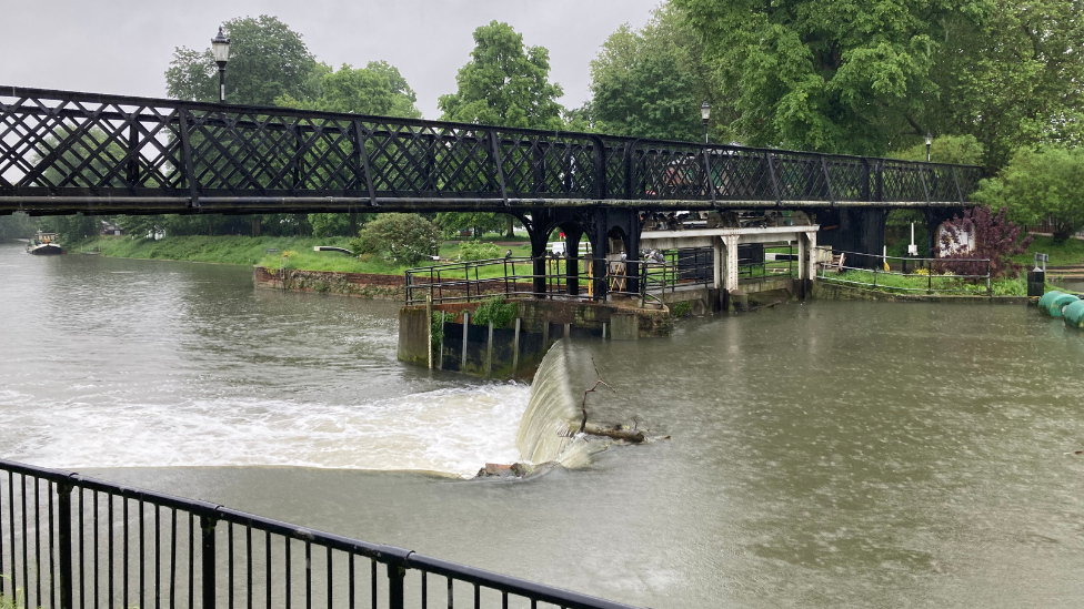 A black footbridge above a river 