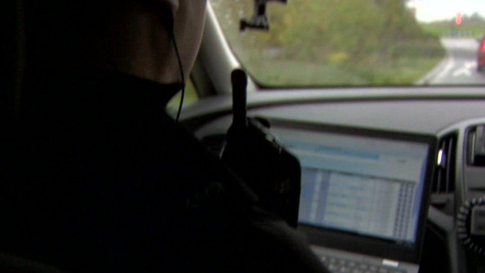 Police officer looking at laptop