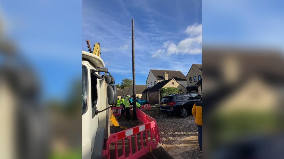 A wooden pole being installed in Willersey